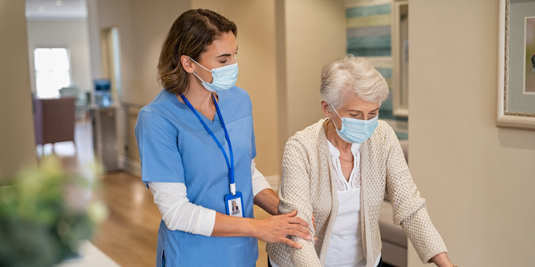 Female nurse assisting a elderly patient on a walking frame
