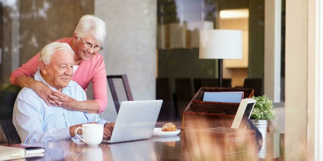 Senior couple using laptop on desk at home