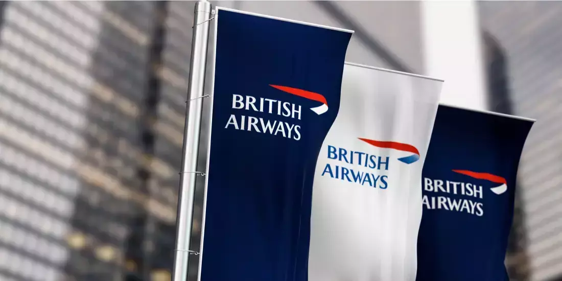 Three British Airways flags flying outside office blocks