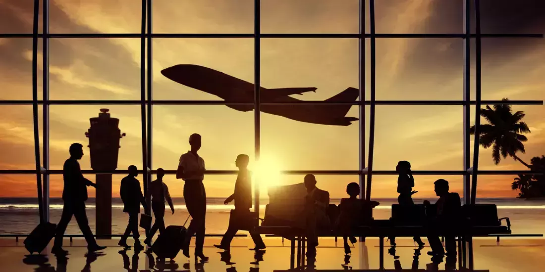Silhouettes of air passengers waiting and a plane taking off