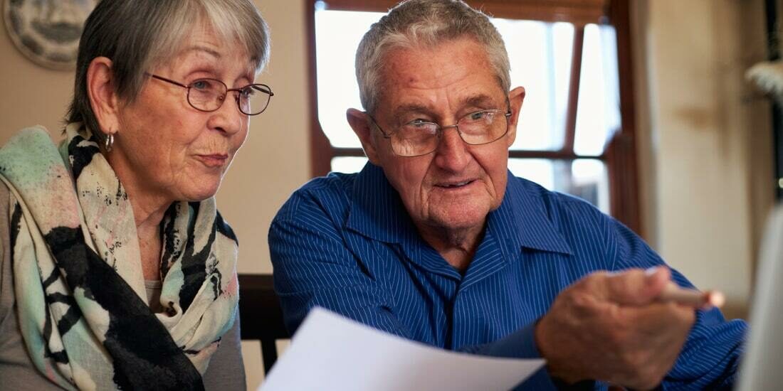 Elderly couple check documents on their computer