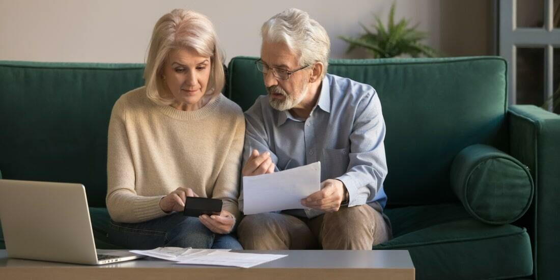 A middle aged couple sorting through documents together in their lounge