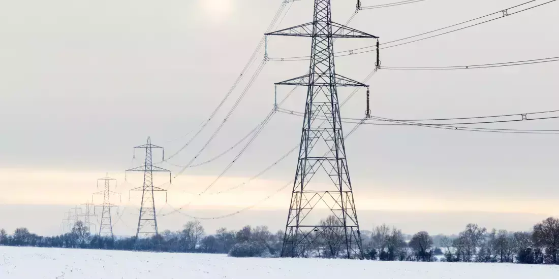 Electricity pylons across a field in winter