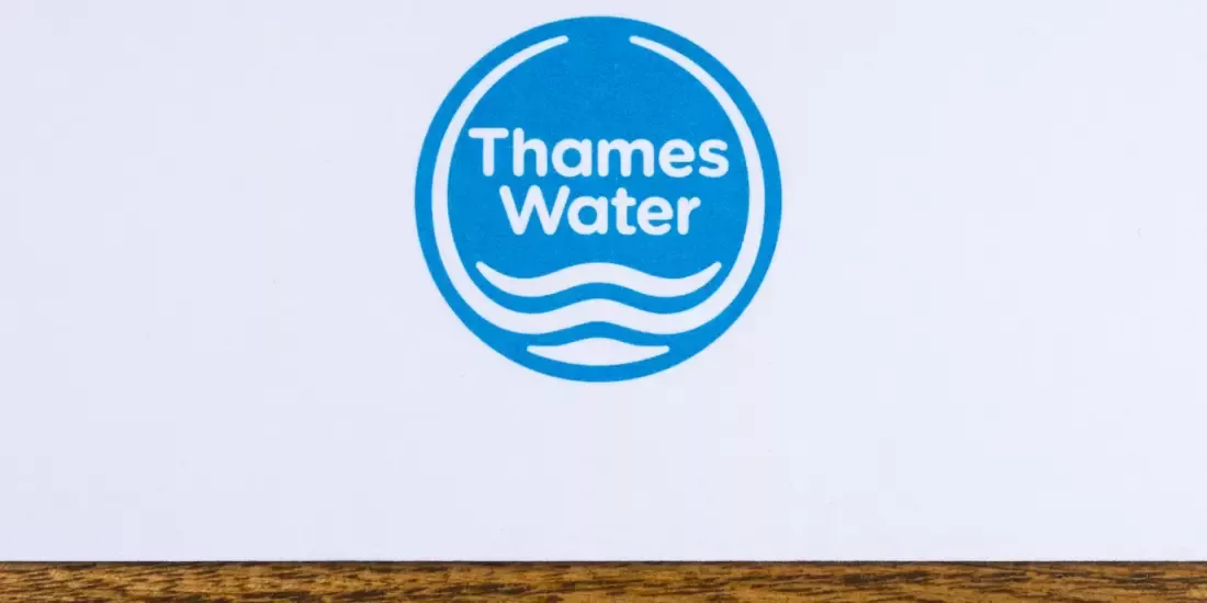 Thames Water logo on a piece of paper on a wooden tabletop